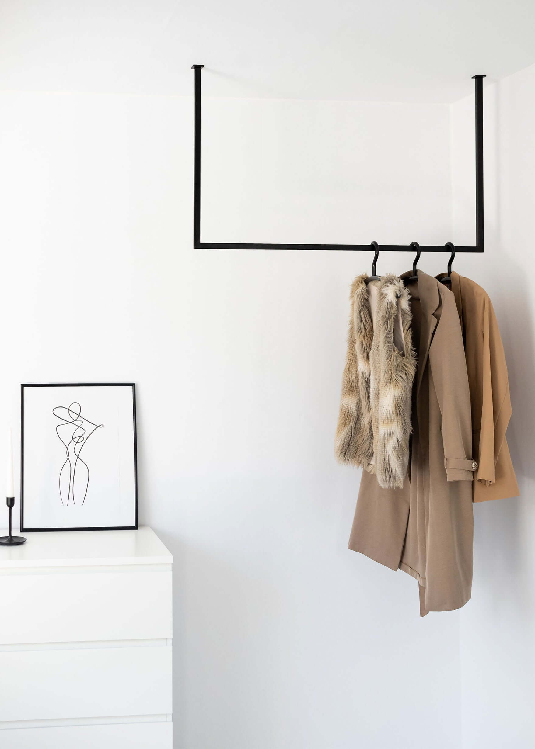 Schwarze Kleiderstange in einem Schwarz-Weißem Schlafzimmer