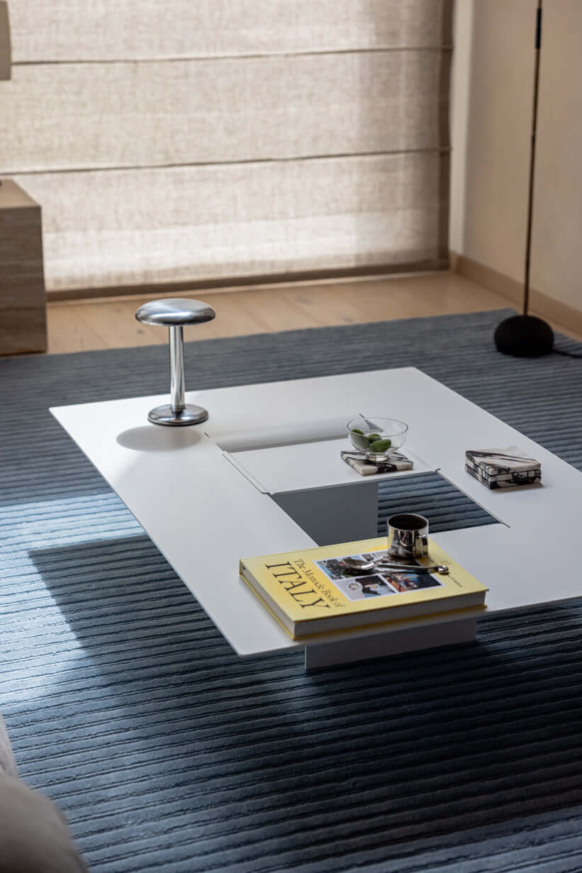 Moderer Couchtisch CUT aus pulverbeschichtetem Stahl mit minimalistischen Design und zentraler Öffnung.